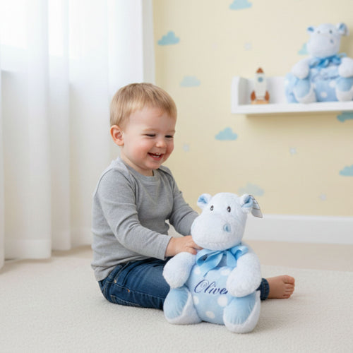 Little boy playing with personalised blue hippo Sky soft toy with blanket
