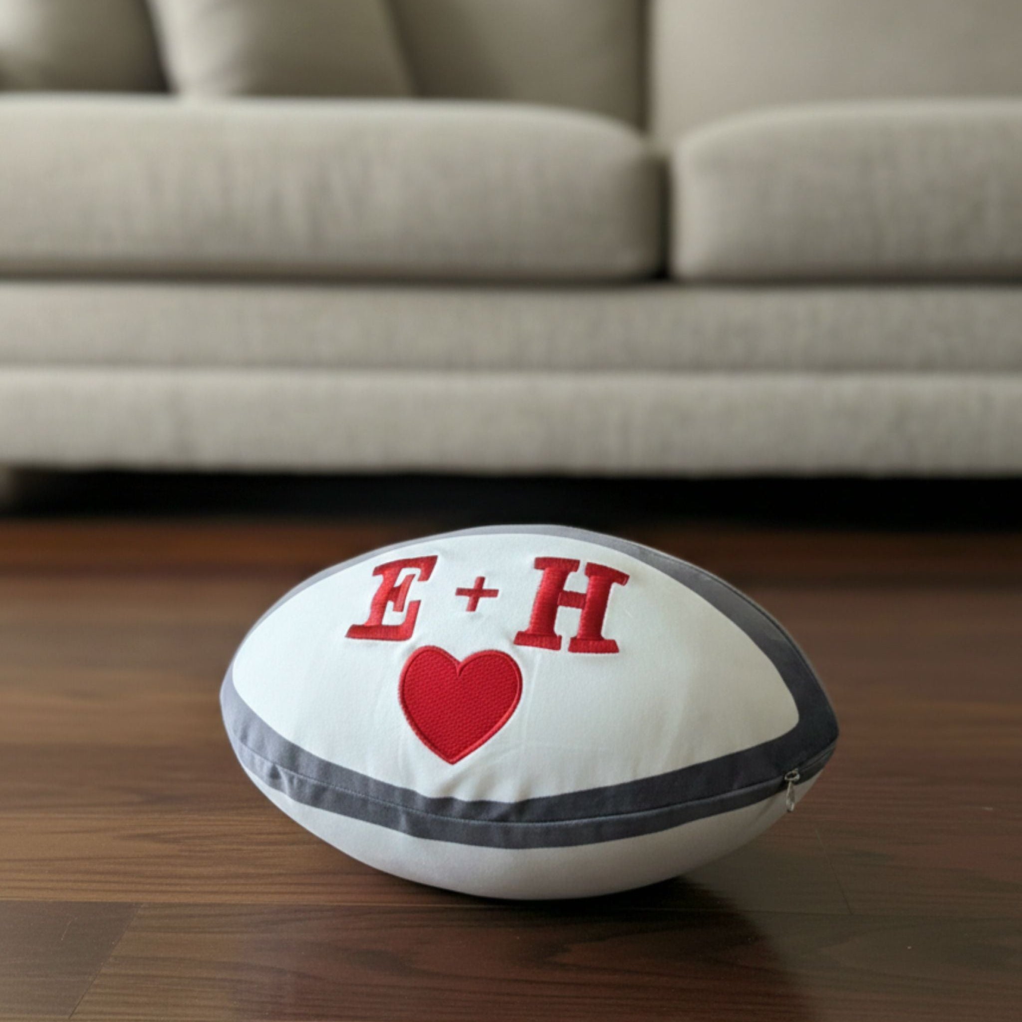 Front view of a personalised plush rugby ball with custom name embroidery