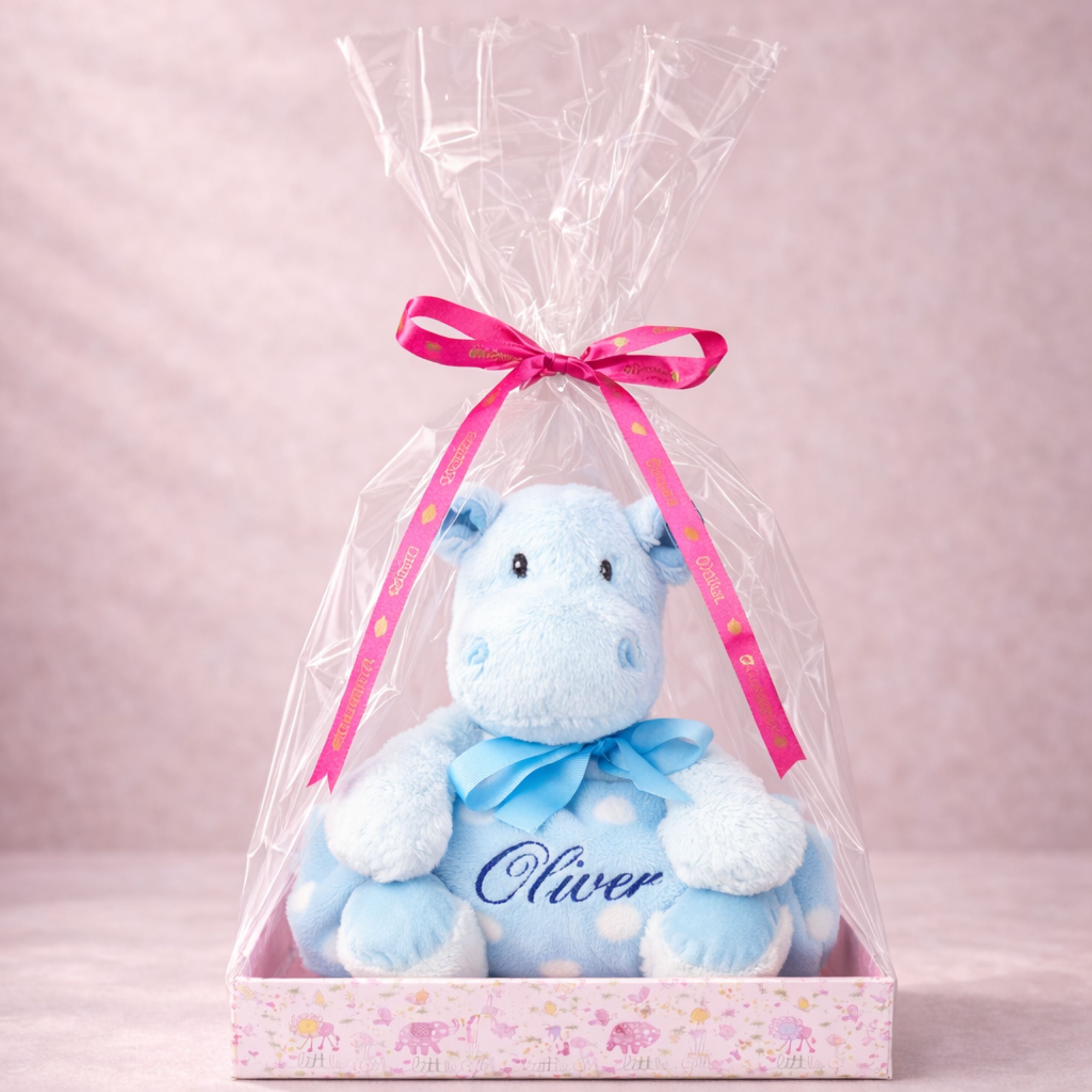 Personalised blue hippo plush toy Oliver wrapped in a pink gift box with clear cellophane