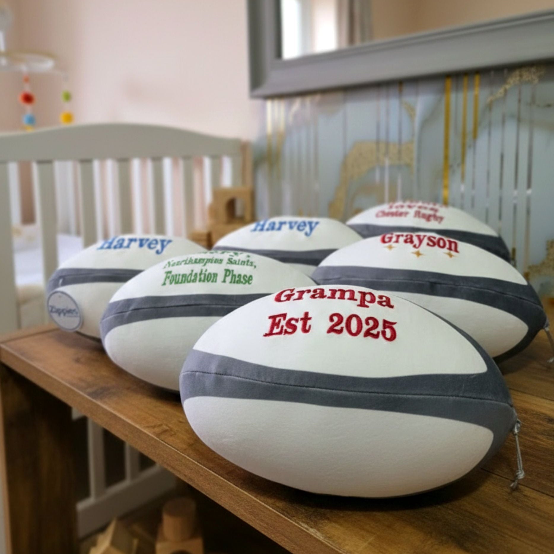 Personalised plush rugby ball on display in nursery with custom name embroidery