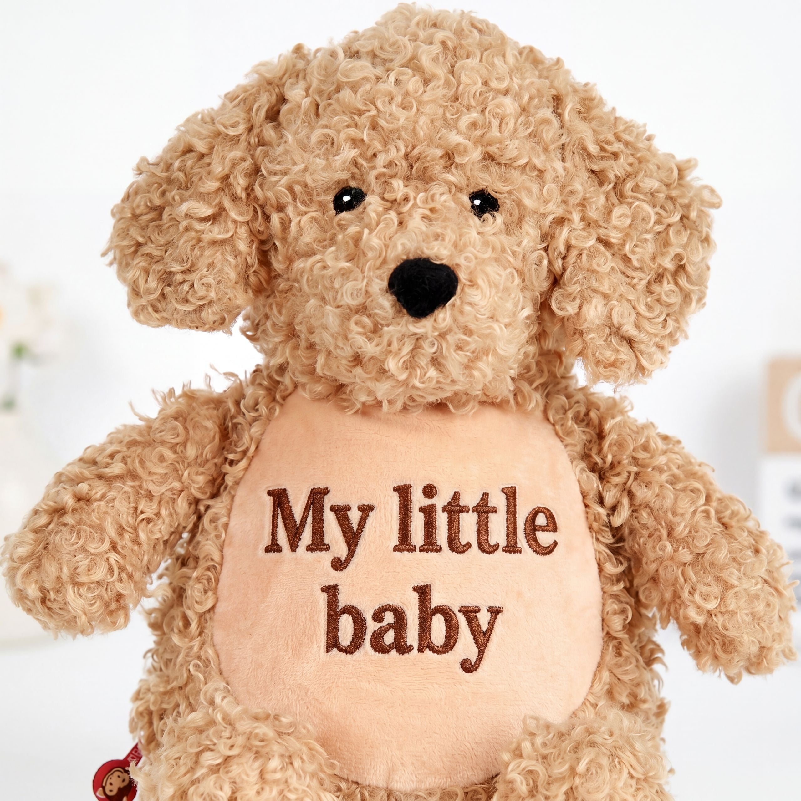 Close-up of personalised embroidery on Labradoodle plush toy Baffy, showing custom stitched name on soft teddy dog