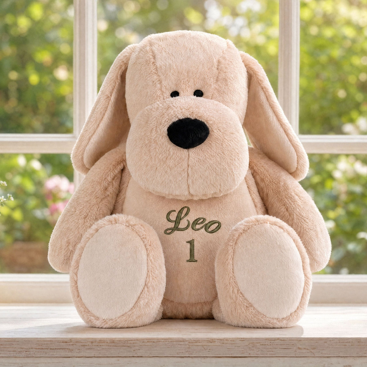 Personalised plush dog Pip sitting on a windowsill in a bright home