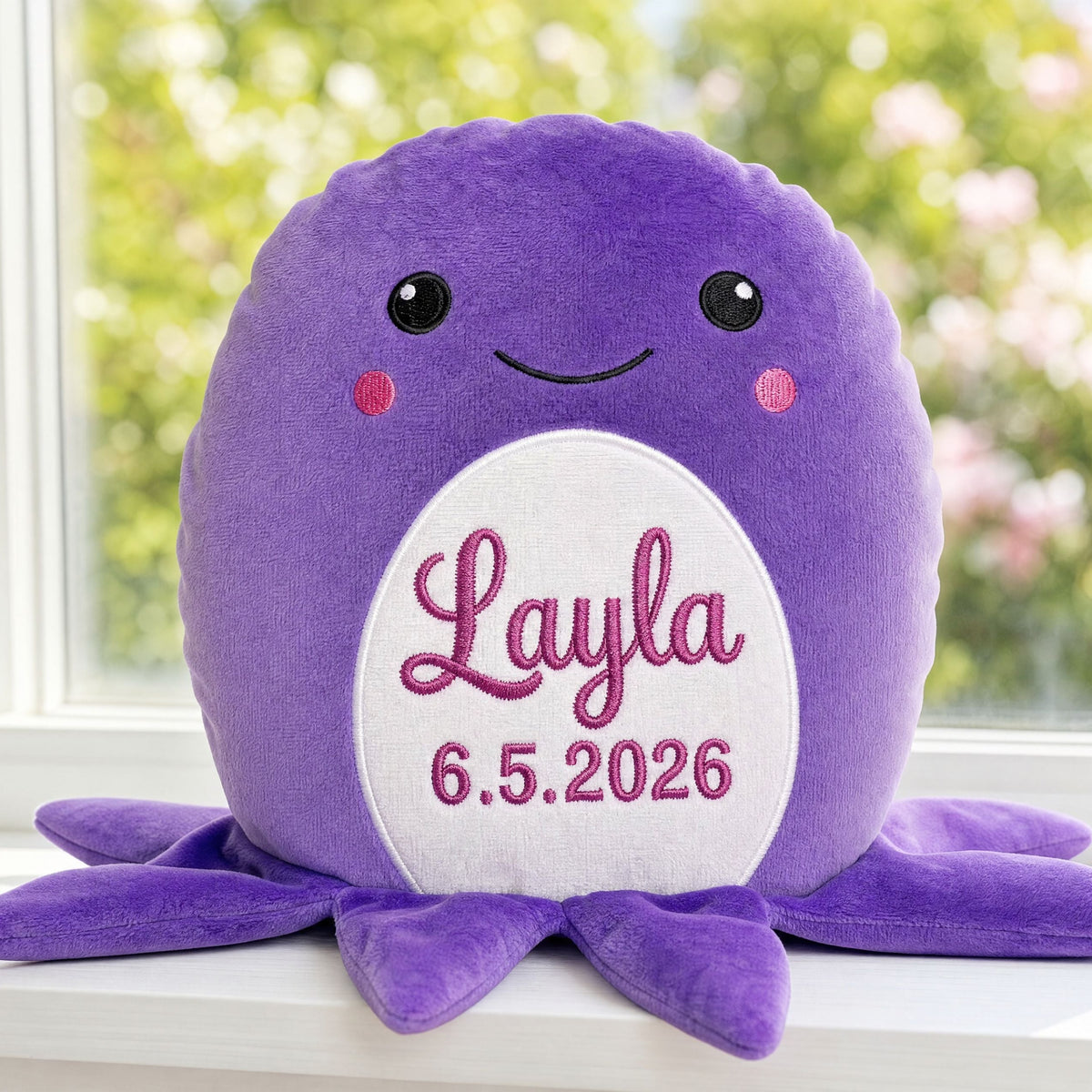 Personalised plush octopus Clover with embroidered name sitting on a windowsill