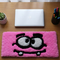 Handmade tufted keyboard rug featuring quirky pink cartoon character with big eyes and tooth