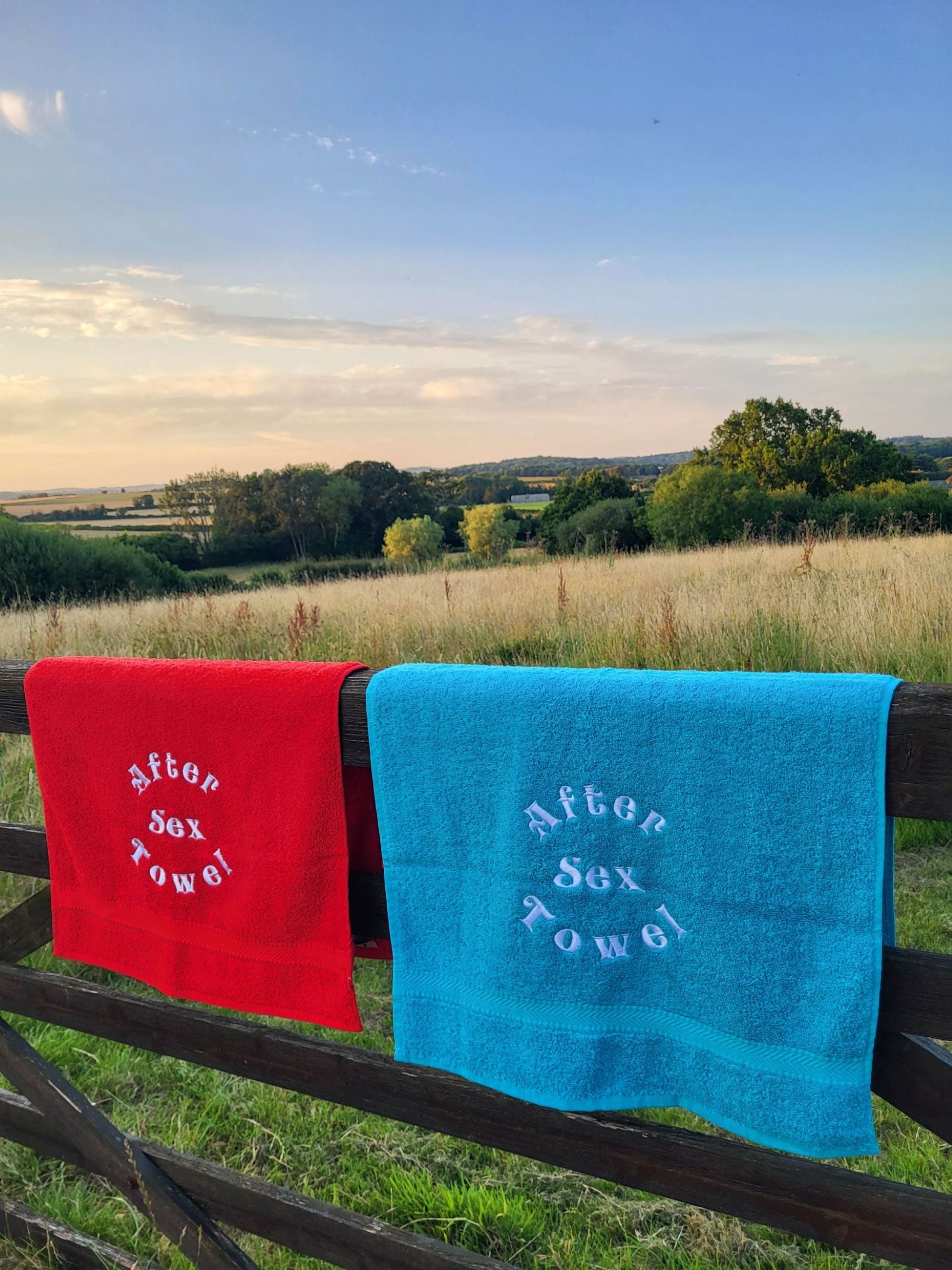 Soft towel outdoors over a wooden fence, drying in natural sunlight