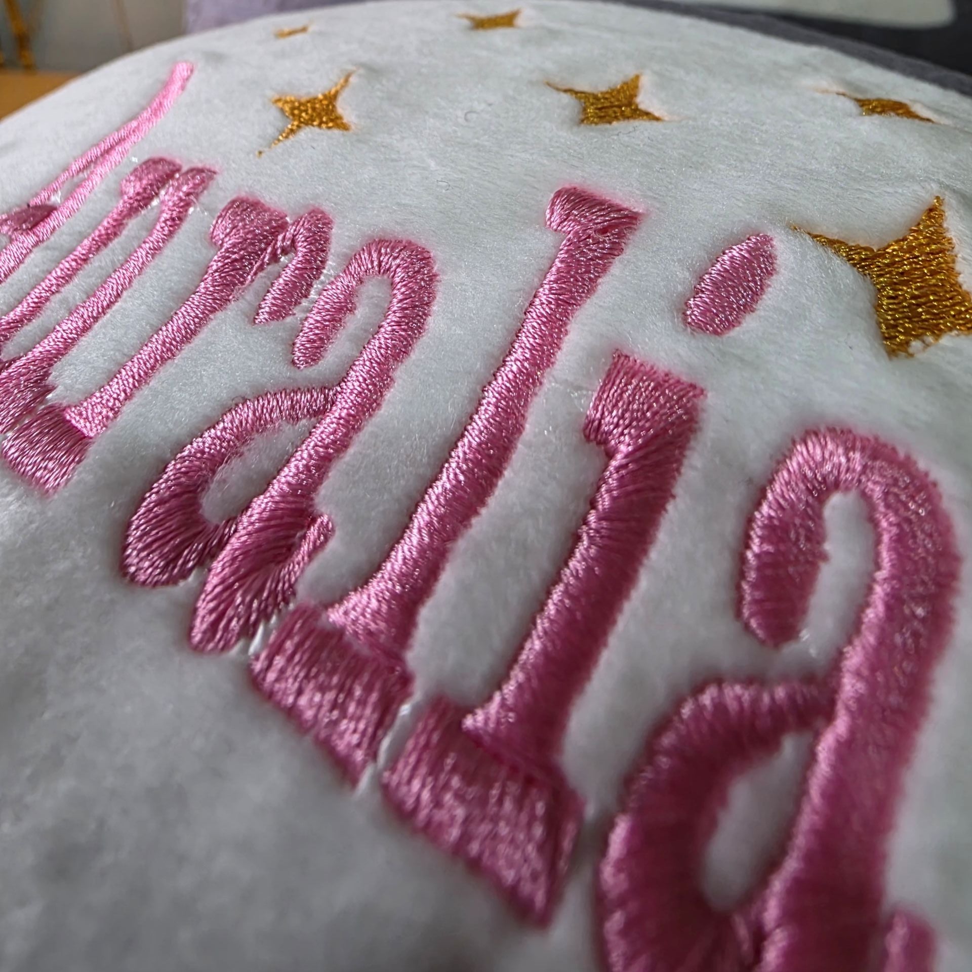 Close-up of Zippy personalised plush rugby ball embroidery with custom name and decorative stars